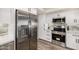Gourmet kitchen featuring a stainless steel refrigerator, modern appliances, and white cabinets at 19 E Boca Raton Rd, Phoenix, AZ 85022