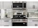 Close up of the kitchen featuring stainless steel oven, microwave, and gray subway tile backsplash at 19 E Boca Raton Rd, Phoenix, AZ 85022