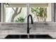 Modern kitchen sink with black faucet and a window overlooking lush greenery at 19 E Boca Raton Rd, Phoenix, AZ 85022