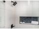 Close-up of a modern shower with a rainfall showerhead, white tile, and a built-in storage niche at 19 E Boca Raton Rd, Phoenix, AZ 85022