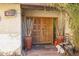 Elegant front entrance with a carved wood door, lush greenery, and decorative pots at 1908 E Beck Ln, Phoenix, AZ 85022