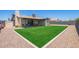 Landscaped backyard with artificial grass area and a covered patio for outdoor entertaining at 1937 E Loyola Dr, Tempe, AZ 85282