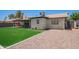 Backyard with artificial grass, rock landscaping, and a covered patio at 1937 E Loyola Dr, Tempe, AZ 85282