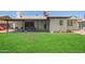 Landscaped backyard with artificial grass area and a covered patio, perfect for relaxing at 1937 E Loyola Dr, Tempe, AZ 85282