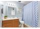 Well-lit bathroom with a single sink vanity, a mirror, and a blue and white checkered shower curtain at 1937 E Loyola Dr, Tempe, AZ 85282