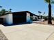 Charming single-story home with a brick exterior, dark garage door, palm trees and desert landscaping at 1941 E Ellis Dr, Tempe, AZ 85282