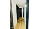 Hallway featuring dark doors, hardwood floors, white walls, modern lighting and dark trim at 1941 E Ellis Dr, Tempe, AZ 85282