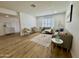 Bright living room featuring modern neutral decor, wood floors, and a window with shutter style blinds at 1941 E Ellis Dr, Tempe, AZ 85282