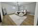 Bright bedroom with shuttered window, wood floors, neutral paint, and plush rug at 1941 E Ellis Dr, Tempe, AZ 85282