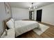 Bright main bedroom featuring wood floors, modern lighting, neutral paint, and white bedding at 1941 E Ellis Dr, Tempe, AZ 85282