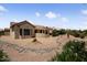 Backyard view of the home featuring desert landscaping and covered patio at 20007 N Siesta Rock Dr, Surprise, AZ 85374