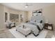 Bright staged bedroom with neutral walls, tiled floor, ceiling fan, and a bay window overlooking the landscaped yard at 20007 N Siesta Rock Dr, Surprise, AZ 85374