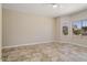 Large bedroom with neutral walls, tiled floors, ceiling fan, and windows providing natural light and views of the yard at 20007 N Siesta Rock Dr, Surprise, AZ 85374