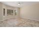 Bright bedroom with neutral walls, tiled floor, ceiling fan, and a bay window overlooking the landscaped yard at 20007 N Siesta Rock Dr, Surprise, AZ 85374