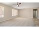 Spacious living room featuring carpet and tile flooring, neutral walls, ceiling fan, and natural light at 20007 N Siesta Rock Dr, Surprise, AZ 85374