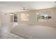 Spacious living room with carpet and tile flooring, neutral walls, ceiling fan, and natural light at 20007 N Siesta Rock Dr, Surprise, AZ 85374