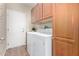 The laundry room features tile floors, a washer, a dryer and storage cabinets at 20223 N Sundance Way, Surprise, AZ 85374