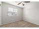 Bedroom with neutral carpet, ceiling fan, and a window with blinds offering natural light at 2028 N 77Th Ln, Phoenix, AZ 85035