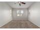 Bright, carpeted bedroom with ample natural light from multiple windows and a ceiling fan at 2028 N 77Th Ln, Phoenix, AZ 85035