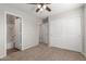 Bedroom with plush carpet, ceiling fan, and closet with sliding doors at 2028 N 77Th Ln, Phoenix, AZ 85035
