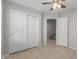 Bedroom with sliding closet doors and tile floor at 2028 N 77Th Ln, Phoenix, AZ 85035