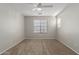 Spacious carpeted bedroom with large windows, neutral walls, and a ceiling fan at 2028 N 77Th Ln, Phoenix, AZ 85035