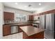 Well-equipped kitchen with stainless steel appliances, center island, and tile backsplash at 2028 N 77Th Ln, Phoenix, AZ 85035