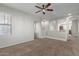 Open living room with neutral walls, carpet floors, and arched openings to other rooms at 2028 N 77Th Ln, Phoenix, AZ 85035