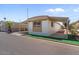 A mobile home with a covered porch, rock landscaping, and a carport at 2121 N Center St # 198, Mesa, AZ 85201