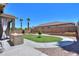 Spacious backyard includes an outdoor kitchen, lush lawn, and mature palm trees at 22121 N Greenland Park Dr, Maricopa, AZ 85139