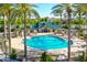 View of the fenced community pool with palm trees, seating and playground at 22121 N Greenland Park Dr, Maricopa, AZ 85139
