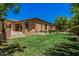 Spacious backyard featuring a covered patio, lush lawn, and manicured landscaping at 24348 S 201St Ct, Queen Creek, AZ 85142
