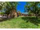 Lush green backyard with mature trees and a gazebo, perfect for outdoor entertaining at 24348 S 201St Ct, Queen Creek, AZ 85142
