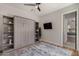 Bedroom with a Murphy bed, built-in shelves, hardwood floors and a ceiling fan, offering style and function at 24348 S 201St Ct, Queen Creek, AZ 85142