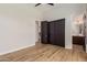 Bedroom with wood floors, ceiling fan, and a closet visible through a partially opened door at 24348 S 201St Ct, Queen Creek, AZ 85142