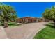 Beautiful home featuring an oversized three-car garage and stylish paver driveway, complemented by green grass at 24348 S 201St Ct, Queen Creek, AZ 85142