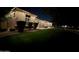 An exterior view of a home featuring well-maintained lawn and professional landscaping at night at 24348 S 201St Ct, Queen Creek, AZ 85142