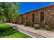 Charming walkway featuring stone accents, lush greenery, and stone exterior walls at 24348 S 201St Ct, Queen Creek, AZ 85142