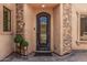 An elegant front door with stone accents and decorative ironwork, offering a grand entrance to the home at 24348 S 201St Ct, Queen Creek, AZ 85142