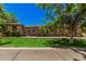 Stunning single-story stone home with lush green lawn and mature trees under a clear blue sky at 24348 S 201St Ct, Queen Creek, AZ 85142