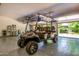 Spacious garage showcasing golf cart, shiny epoxy flooring, and access to outside at 24348 S 201St Ct, Queen Creek, AZ 85142