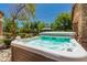 Inviting hot tub in a landscaped backyard setting with mature trees and a view of the gazebo at 24348 S 201St Ct, Queen Creek, AZ 85142