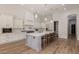 Well-lit kitchen featuring white cabinetry, stone countertops, stainless appliances, and a gray island at 24348 S 201St Ct, Queen Creek, AZ 85142
