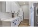 Laundry room with abundant white cabinets, stone countertops, and modern sink, perfect for organization at 24348 S 201St Ct, Queen Creek, AZ 85142