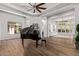 Bright living room features tray ceilings, wood floors and an elegant grand piano at 24348 S 201St Ct, Queen Creek, AZ 85142