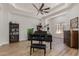 Spacious living room featuring a grand piano, beautiful hardwood floors, and ample natural light at 24348 S 201St Ct, Queen Creek, AZ 85142