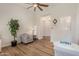 Open floor plan of a living room with laminate flooring, a ceiling fan, and natural light at 24348 S 201St Ct, Queen Creek, AZ 85142