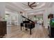 Open-concept living area with a grand piano, seamlessly connecting to other living spaces and the outdoors at 24348 S 201St Ct, Queen Creek, AZ 85142