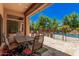 Outdoor dining area on a spacious patio, offering a serene view of the backyard and pool at 24348 S 201St Ct, Queen Creek, AZ 85142