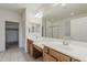 Bathroom featuring a large mirror, double sinks, and an adjacent walk-in closet at 27413 W Tonopah Dr, Buckeye, AZ 85396